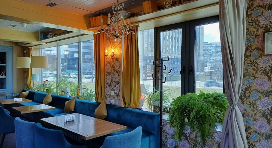 Restaurant Kukhnya Polli - bright and cozy dining room with simple wooden tables and large windows