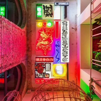 Restaurant Kytaiskyi Pryvit - colorful interior wall display of stacked neon signs and artwork