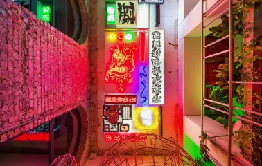 Restaurant Kytaiskyi Pryvit - colorful interior wall display of stacked neon signs and artwork