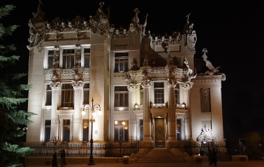 Budynok Horodetskoho in Kyiv - illuminated castle with mystical sculptures against the night sky