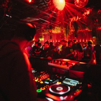 DJ at the console under the red light at Juice / NoCap club in Kyiv