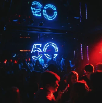 Fifty Club - neon 50 sign glowing above crowd in dark club