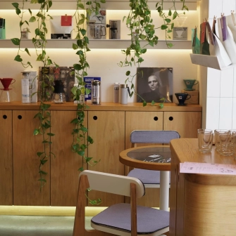 Takava in Kyiv - coffee shelf display with hanging plants and brewing equipment