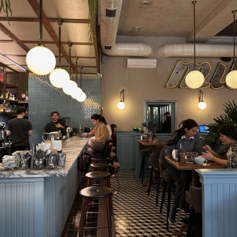 Interior of Milk Bar cafe in Kyiv with soft lighting and visitors at tables