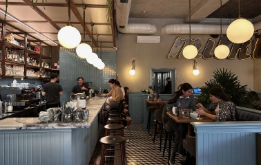 Interior of Milk Bar cafe in Kyiv with soft lighting and visitors at tables