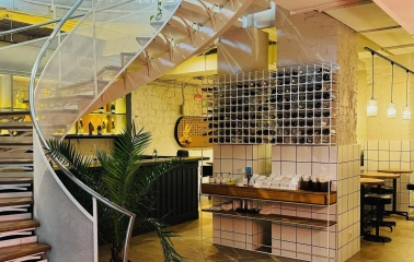 Restaurant Trishky Bilshe - interior view of a spiral staircase next to a wine rack display
