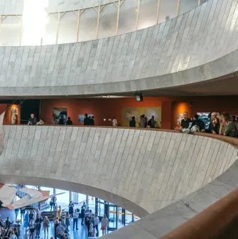 Ukrainskyi Dim in Kyiv - curved white marble balconies overlooking the art exhibition hall filled with people