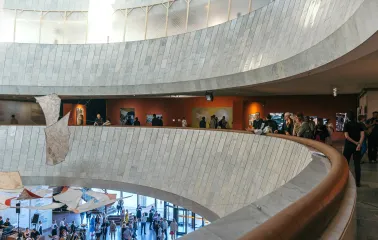 Ukrainskyi Dim in Kyiv - curved white marble balconies overlooking the art exhibition hall filled with people
