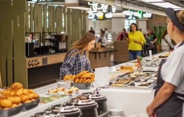Restaurant Puzata Hata - customer selecting food from the long buffet line
