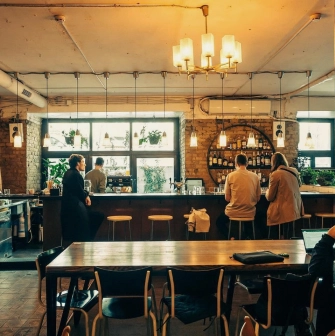Bar Restaurant Kosatka - dining area with a long table and a view of the bar counter through a window