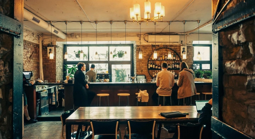 Bar Restaurant Kosatka - dining area with a long table and a view of the bar counter through a window