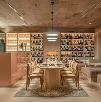 Cozy room with a large wooden table and tall shelves filled with wine bottles