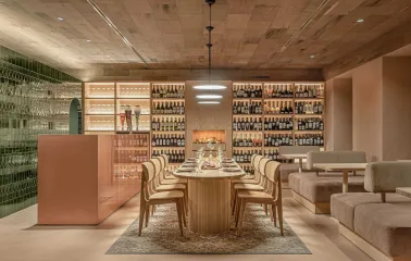 Cozy room with a large wooden table and tall shelves filled with wine bottles