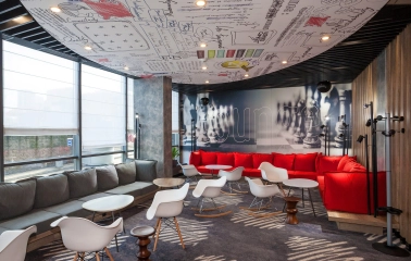 Ibis Railway Station in Kyiv - lounge with red sofas and ceiling graffiti