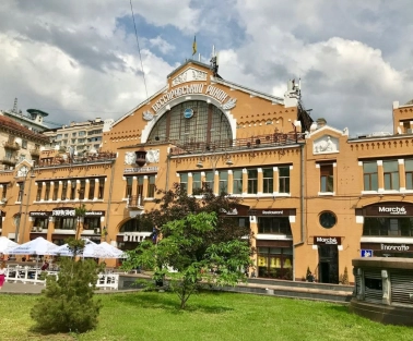 Facade of the Bessarabian Market in Kyiv with a terrace and summer tables
