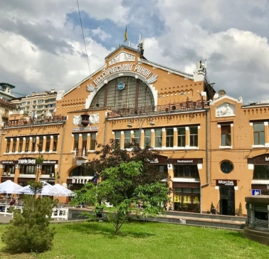 Facade of the Bessarabian Market in Kyiv with a terrace and summer tables