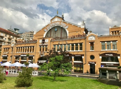 Facade of the Bessarabian Market in Kyiv with a terrace and summer tables