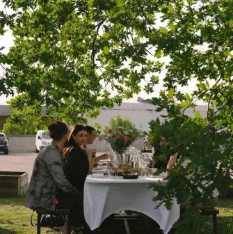 Group of people dining at a white-tablecloth table on the restaurant terrace