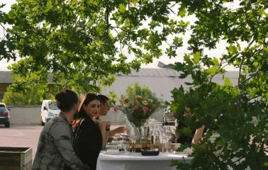 Group of people dining at a white-tablecloth table on the restaurant terrace