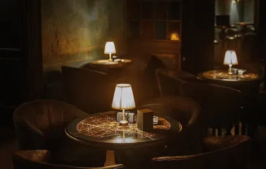 Restaurant interior with round tables and soft armchairs under dim lighting