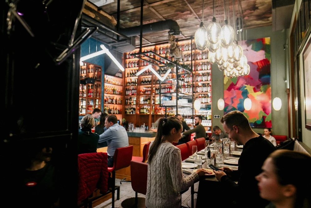 Bar counter and visitors in the hall of Italiiska redaktsiia restaurant