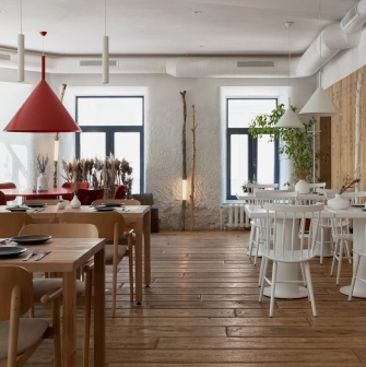 Restaurant 100 Rokiv Tomu Vpered - bright dining hall with white and light wood furniture