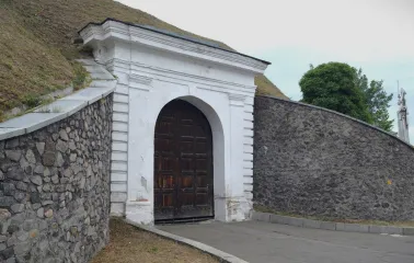 Kyiv Fortress in Kyiv - massive white stone arch with wooden gates built into the wall