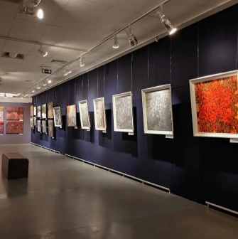 Muzei Istorii Mista Kyieva in Kyiv - art gallery hall with dark blue walls displaying framed paintings