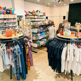 UAmade in Kyiv - cozy shopping corner with round racks of T-shirts and shelves filled with toys