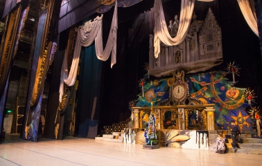 National Opera of Ukraine in Kyiv - atmospheric stage setting for a performance featuring large elegant drapes, a clock, and a festive Christmas tree