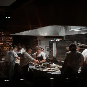 Busy professional kitchen with chefs preparing dishes at a restaurant