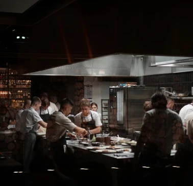 Busy professional kitchen with chefs preparing dishes at a restaurant