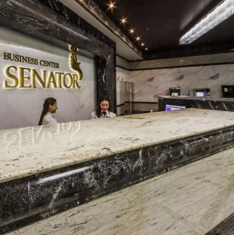 Senator Business Center in Kyiv - marble reception desk with staff and golden logo