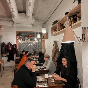 Spelta - dining area with wooden tables industrial lighting and a large counter