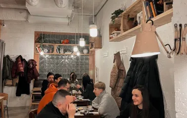 Spelta - dining area with wooden tables industrial lighting and a large counter
