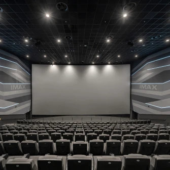 Порожня зала кінотеатру перед великим екраном з логотипом IMAX