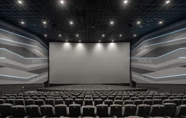 Порожня зала кінотеатру перед великим екраном з логотипом IMAX