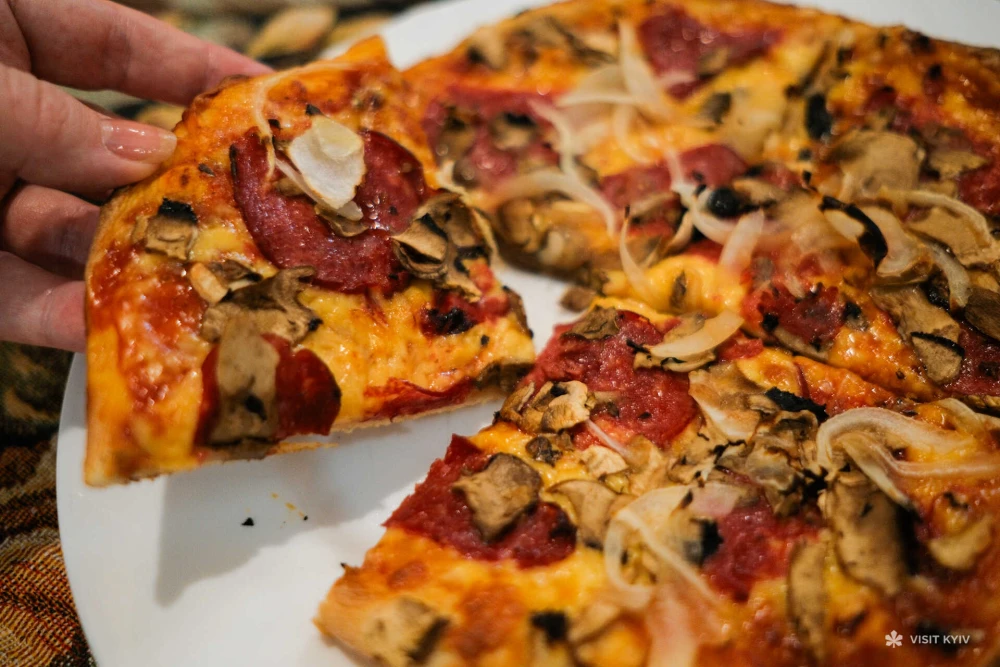 Slice of pizza with mushrooms and salami at Vezuvio pizza