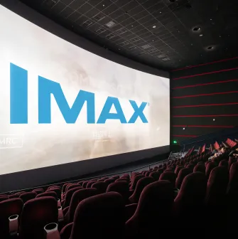 Великий екран IMAX у темній залі кінотеатру з глядачами