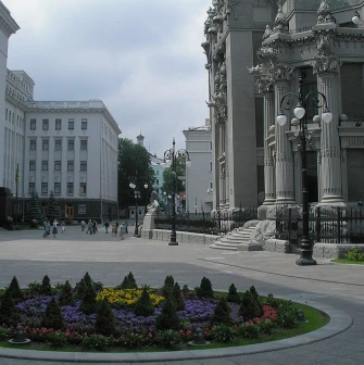 Budynok Horodetskoho in Kyiv - majestic grey facade with columns rising above the flowerbed
