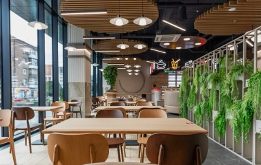 Restaurant Puzata Hata - dining area with wooden tables, vertical gardens, and floor-to-ceiling windows