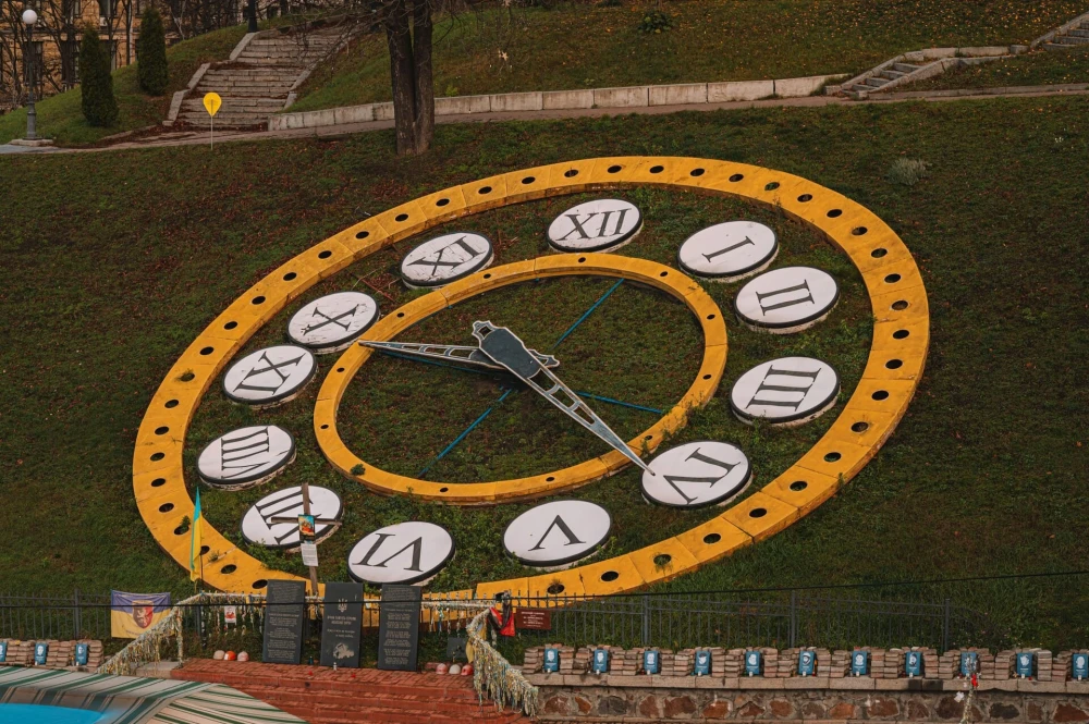 Independence Square in Kyiv - large flower clock on the grassy hill above the memorial wall