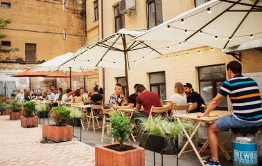 Punkraft - relaxed street terrace with simple wooden tables and strung lights