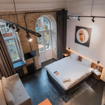 Room with a double bed and a brick wall at Globe Runner Hostel in Kyiv