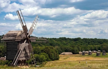 Panorama of the Pies Museum with wooden mills on a green field in Kyiv