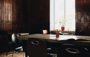 Kashtan - indoor dining area with wooden paneling a large table and sunlight through the window