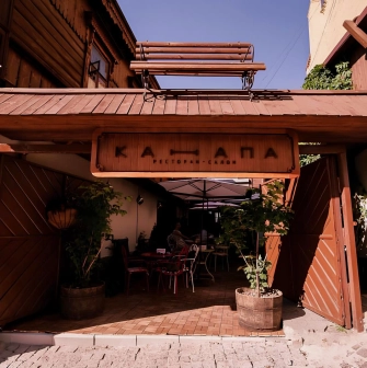 Restaurant Kanapa - wooden restaurant facade with an open archway leading to the patio