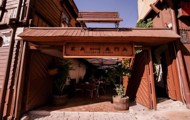 Restaurant Kanapa - wooden restaurant facade with an open archway leading to the patio