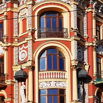 Syrotkin House - arched windows flanked by statues and white patterns