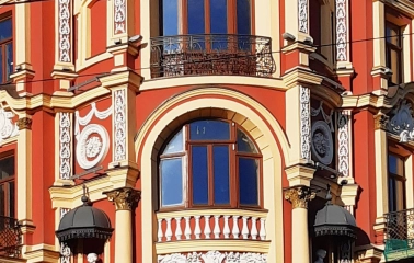 Syrotkin House - arched windows flanked by statues and white patterns